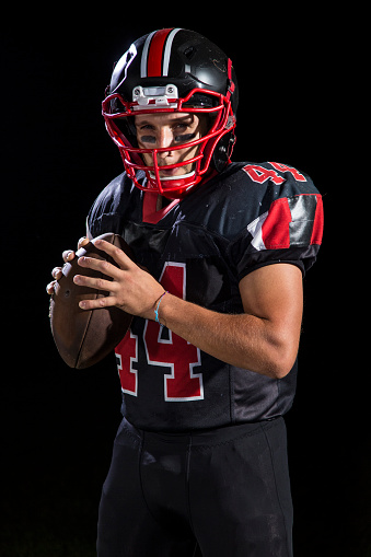 Young American football player standing with arms crossed