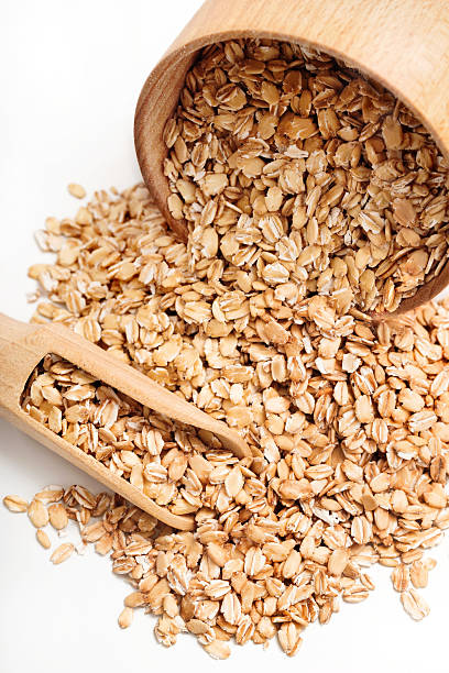 istock Oat flakes scattered from wooden bow 629942322