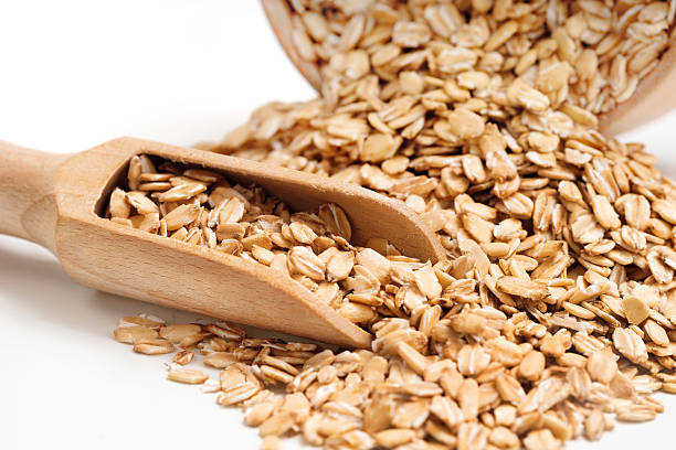 istock Heap oat flakes and scoop on white background 629942408