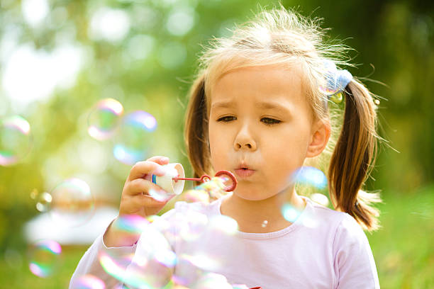 istock Little girl is blowing a soap bubbles 629943034