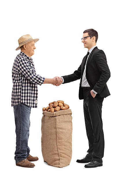 istock Farmer with a burlap sack shaking hand with a businessman 629950714