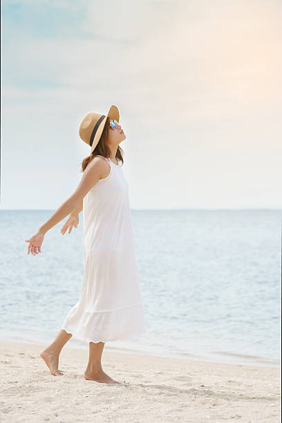 istock Young woman taking a deep breath on the beach 629951240