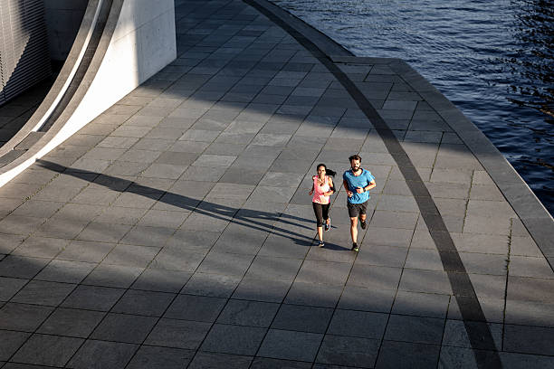 istock Woman and man jogging together 629953136