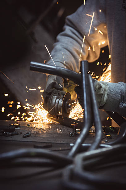 Grinding loops of steel pipe, sparks on a work table stock photo