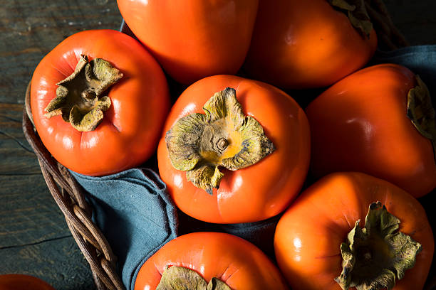 raw organic orange perssimons - persimmon imagens e fotografias de stock