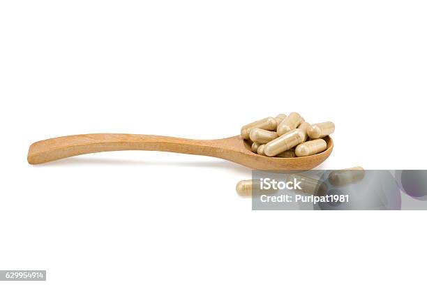 Pills On A Wooden Spoon Isolated On White Background Stock Photo - Download Image Now
