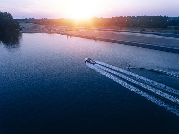 человек водные лыжи на озере за лодкой - wakeboarding waterskiing water ski sunset стоковые фото и изображения