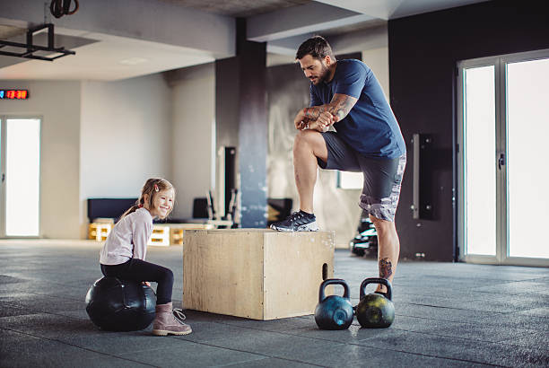 Strengthening their bond Father and his daughter resting, after cross training. Enjoying in their time. crossfit girl stock pictures, royalty-free photos & images
