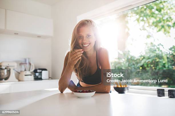 Foto de Mulher Jovem Comendo Café Da Manhã Saudável e mais fotos de stock de Mulheres - Mulheres, Comer, Cozinha