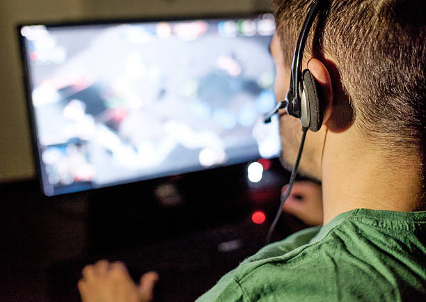 istock Man playing video game in dark room 629961152