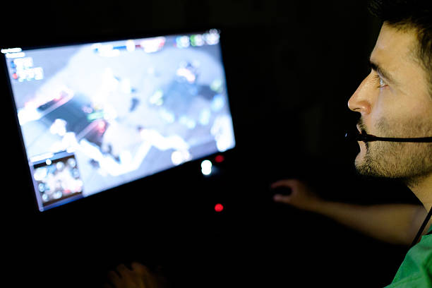 istock Man playing video game in dark room 629961324