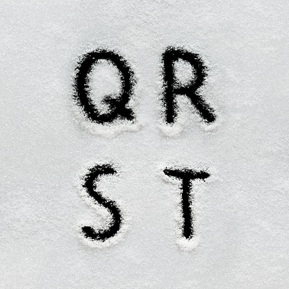 Winter alphabet, symbols and numbers hand written on snow. Black background isolated. Letters Q, R, S, T.