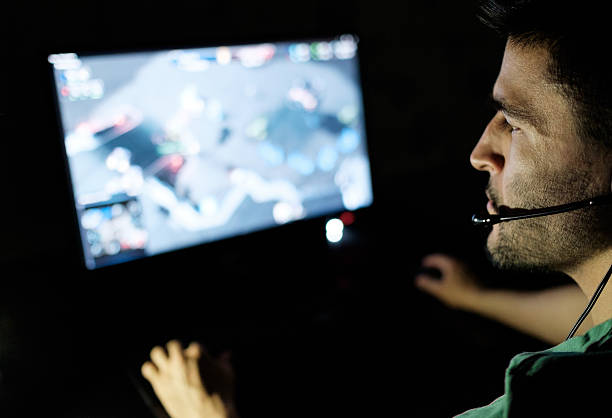 istock Man playing video game in dark room 629961478