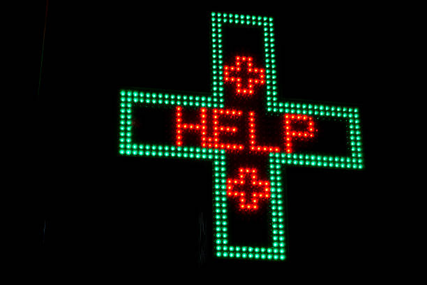 istock Illuminated Green and Red neon Pharmacy sign displaying word Help 629961680