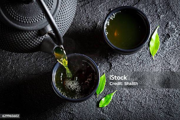 Delicious Green Tea With Teapot And Cup On Black Rock Stock Photo - Download Image Now