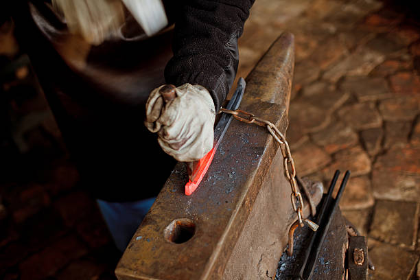 istock The blacksmith manually forging the molten metal 629984220
