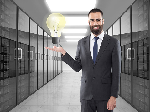 Portrait of businessman holding light bulb on virtual touch screen interface
