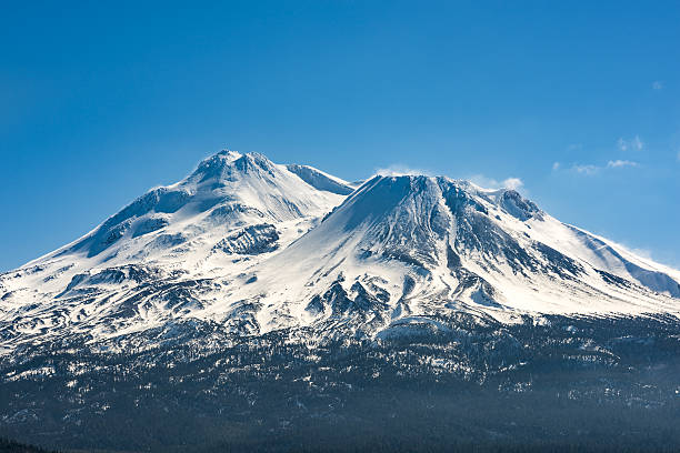 Snowcapped Mount Shasta volcano during winter blue closeup Snowcapped Mount Shasta volcano during winter blue closeup mt shasta photos stock pictures, royalty-free photos & images