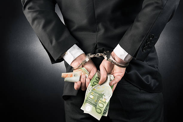 Businessman is arrested and handcuffed with Euro Businessman is arrested and handcuffed with Euro high quality and high resolution studio shoot white collar crime handcuffs stock pictures, royalty-free photos & images