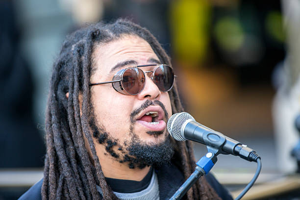 istock Cool singer with dreadlocks in front of mike 629999264
