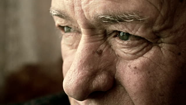 closeup sad and pensive old man's eyes: worried and afraid old man