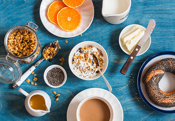 istock Yogurt, pumpkin granola, bagel, butter on a blue table. Breakfast 630006382
