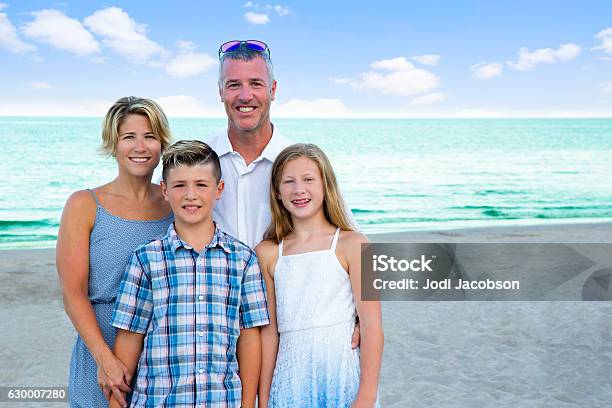 Seriesportrait Of Real Caucasian Family Of Four On Beautiful Beach Stock Photo - Download Image Now