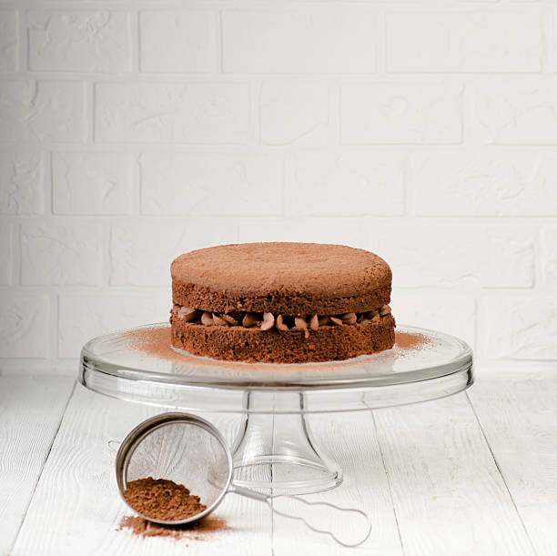 istock Chocolate cake with berries and cocoa powder on white wooden 630007380