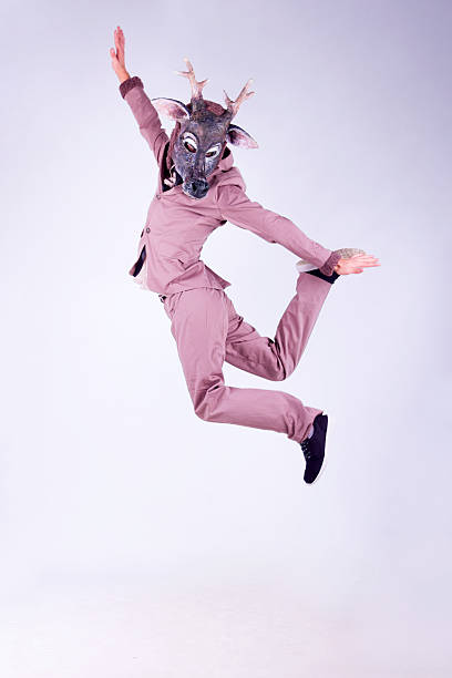 New year deer Young man wearing the mask of deer dancing isolated on white background animal head man stock pictures, royalty-free photos & images