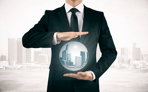 istock Businessman in suit holding sphere with city 630009034