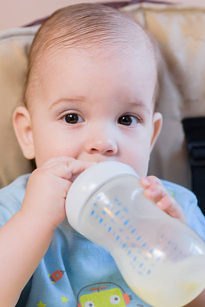 istock baby drinking milk from a bottle in the apartment 630010238
