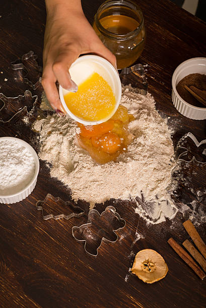 istock Preparing pastry for gingerbread. Pouring melted butter to flour. 630018840