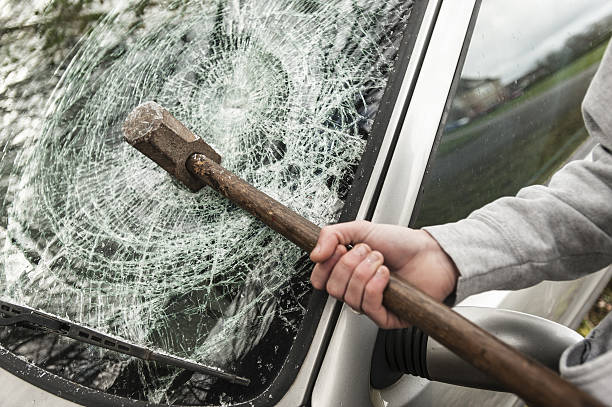 sledge hammer in a car windscreen. - vandalism imagens e fotografias de stock
