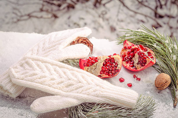 scène d’hiver avec des mitaines chaudes en laine tricot blanche - grenade pin photos et images de collection