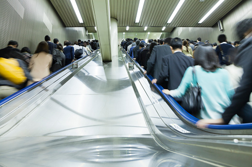 Tokyo, Japan - May 9, 2013: commuters riding the escalators in Tokyo Railroad Station in the morning