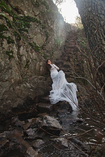 istock Young woman dressed bride sitting on a stone stairs. 630052614