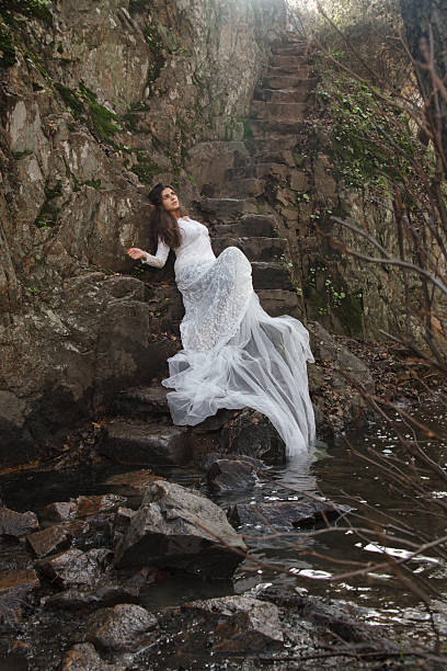 istock Young woman dressed bride sitting on a stone stairs. 630052708