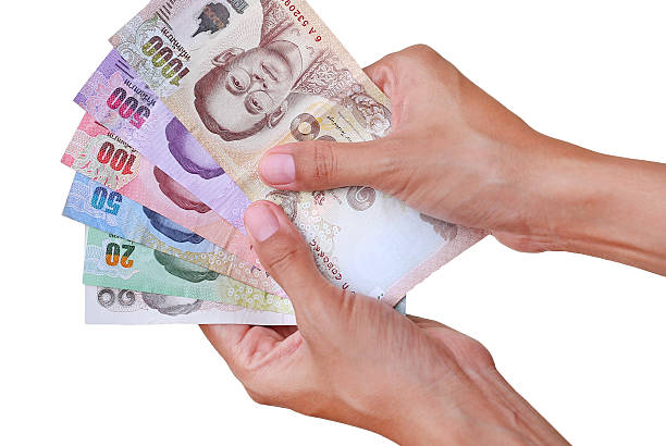 istock Hand holding thai money isolated on white background 630053964