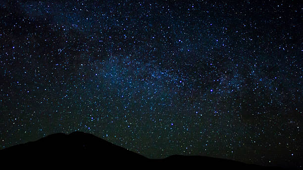 istock Dark hills under a night sky full of brighting stars 630066418