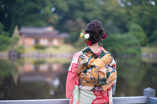 Young Furisode girl in Japanese garden