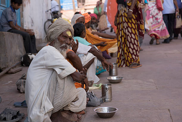 linea di mendicanti seduti fuori da un tempio in india - homelessness food in a row people foto e immagini stock