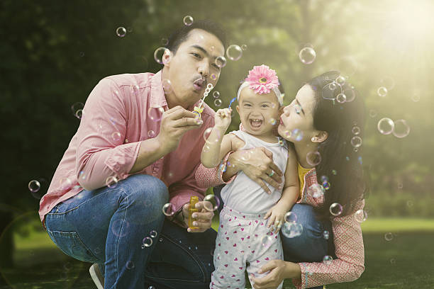 istock Happy family playing with soap bubbles 630070374