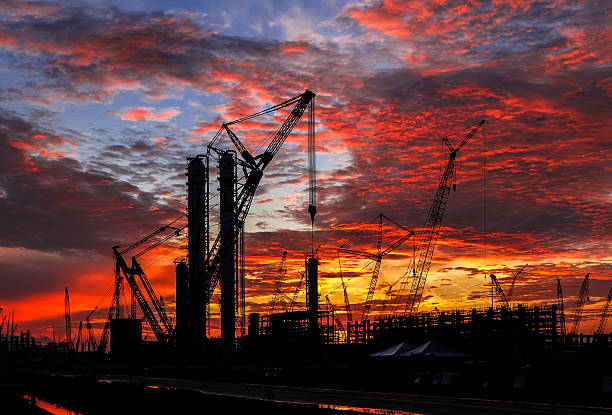istock Silhouette shot of multiple cranes in construction sites. 630620252