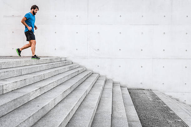 istock sporty man running down steps in urban setting 631184418