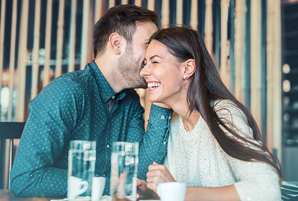 pareja amorosa romántica teniendo una cita en un café - whispering couple discussion smiling fotografías e imágenes de stock