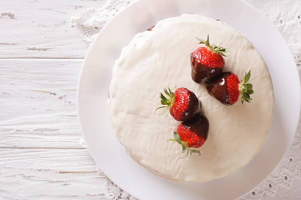 istock cake with white icing and strawberries in chocolate closeup 632218220