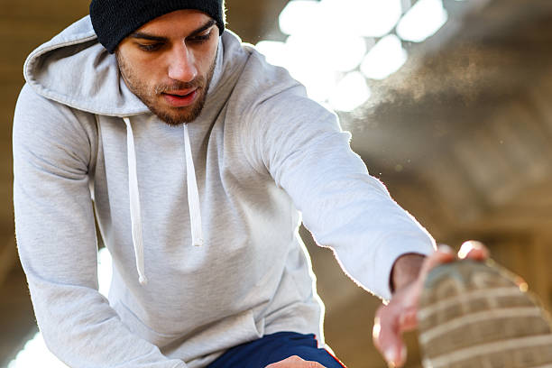 Young man stretching his muscles under the bridge.