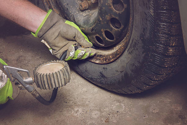 istock Man's hands in protective gloves checking the tire air pressure. 632218782