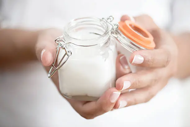 Female hand holding moisturizer jar in hand
