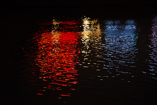 Yellow, blue, red reflection on the water at night of town